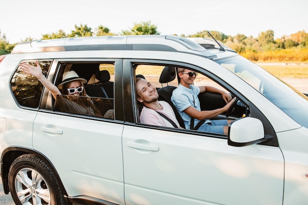 Friends in car looking from the window road trip concept