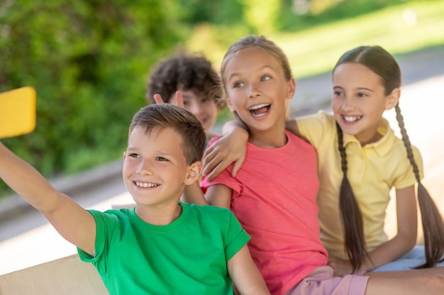 Friends in cheerful mood taking selfie on smartphone