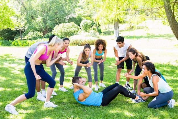 Friends cheering man doing sit ups