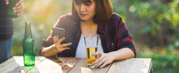 Friends clinking bottle of beer during camping outdoor