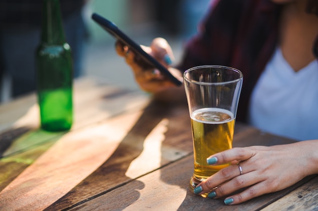 Friends clinking bottle of beer during camping outdoor