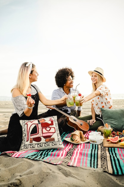 Foto gli amici tintinnano i loro drink ad una festa in spiaggia