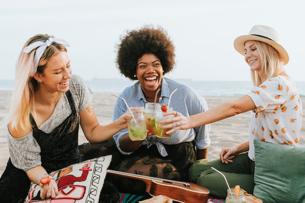 Photo friends clinking their glasses at a beach party