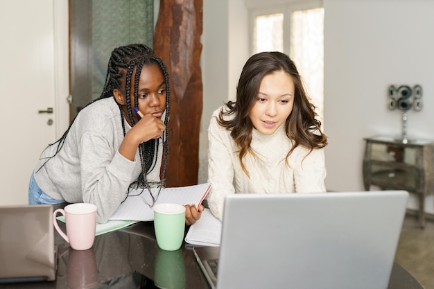 friends discussing over laptop on table at home