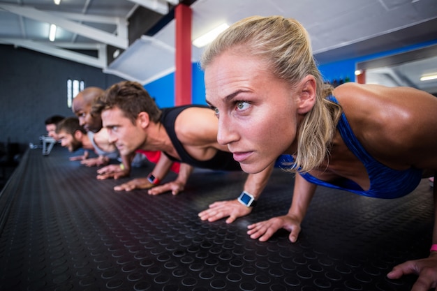 Friends doing push-ups in gym