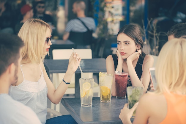 Friends drink cocktails in cafe outdoor