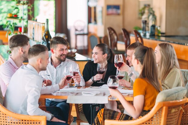 Gli amici bevono vino sulla terrazza del ristorante.