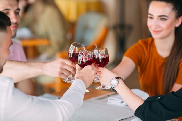 Gli amici bevono vino sulla terrazza del ristorante.