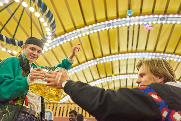 写真 ライトアップされた遊園地でビールを飲む友達