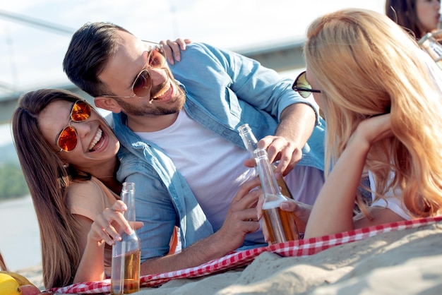 Friends drinking beer on the beach