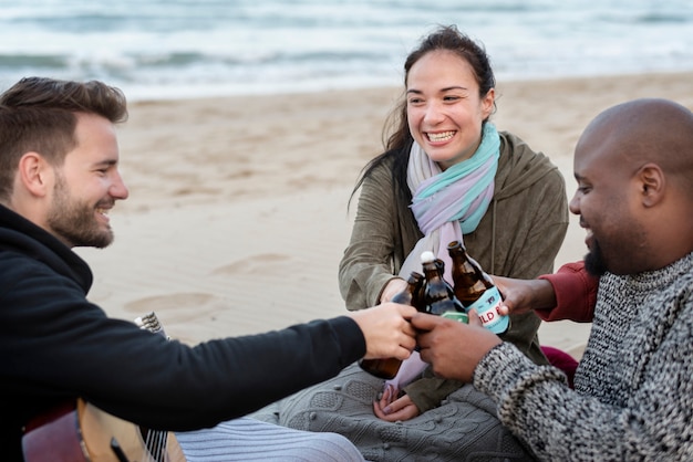 Friends drinking beer on the beach