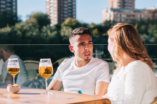 Friends drinking a beer while having a meeting with friends at\
the bar or restaurant.