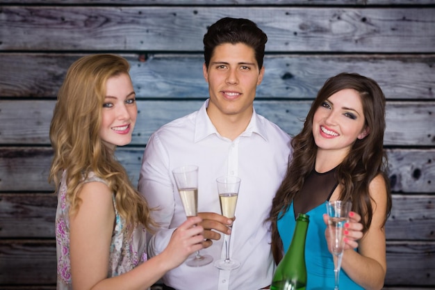 Friends drinking champagne against grey wooden planks