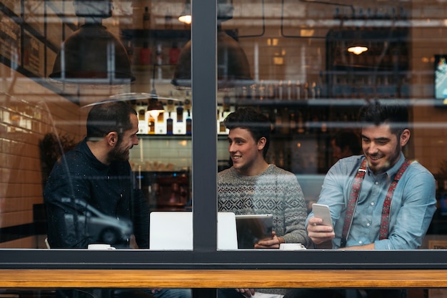 Friends drinking coffee and chatting in cafe.