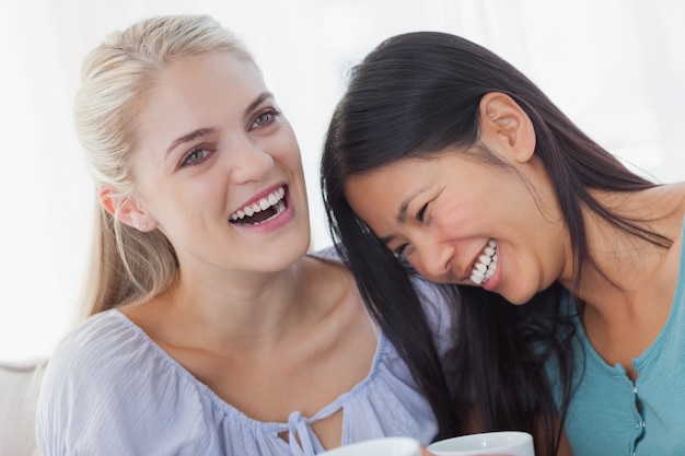 Friends drinking coffee together and laughing