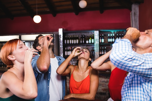 Friends drinking tequila at the table