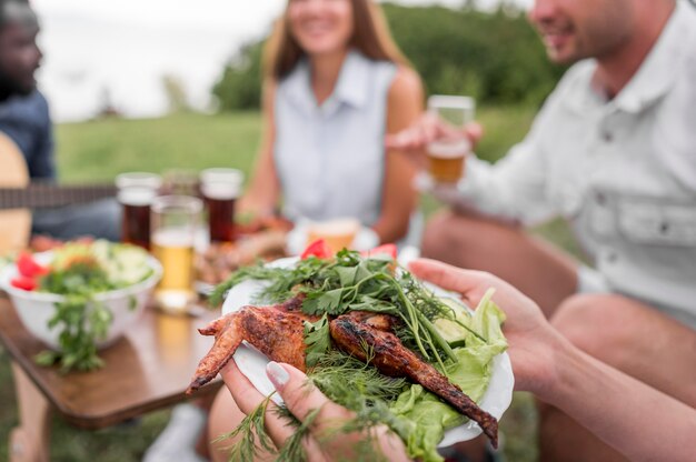 写真 バーベキューで屋外で食べる友達