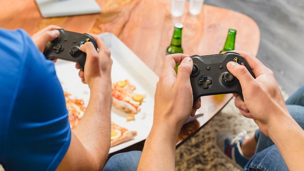 Foto amici che mangiano pizza e giocano sulla console