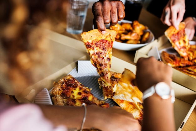 Group Of Friends Eating Pizza Together At Home Stock Photo, Picture and  Royalty Free Image. Image 56950664.