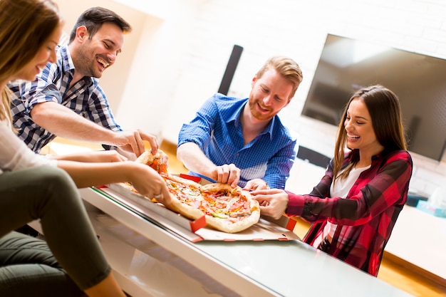 Young friends eating pizza at home on winter reunion - Friendship concept  with happy people enjoying time together and having fun drinking brew pints  Stock Photo - Alamy