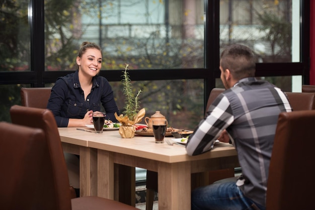 Friends Eating At A Restaurant And Looking Happy