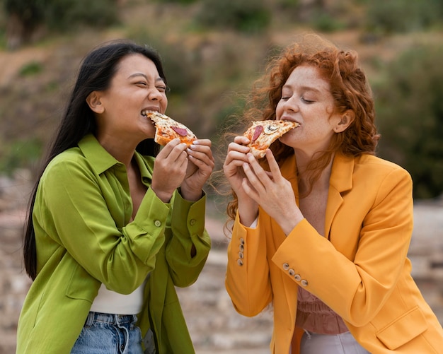 Foto amici che mangiano cibo di strada all'aperto