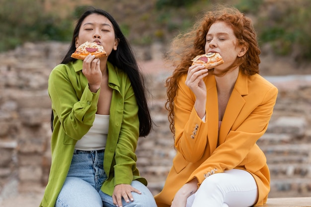 写真 屋外で屋台の食べ物を食べる友達