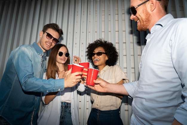 Photo friends enjoying drinks from plastic cups