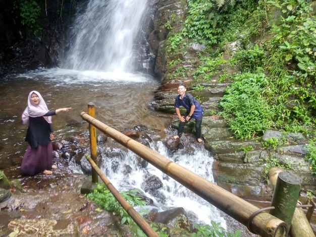 Friends enjoying in river at forest