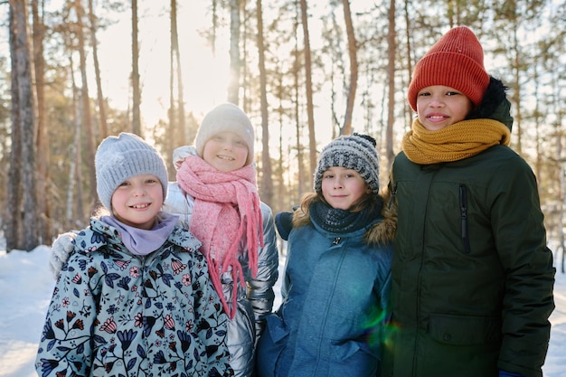 Photo friends enjoying stroll in winter forest