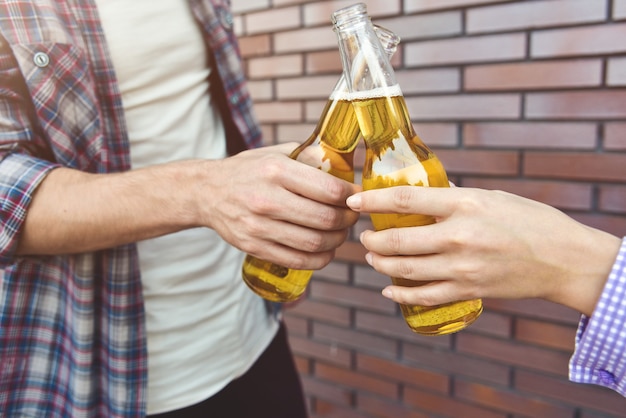 Foto amici che godono con la birra su un muro di mattoni marrone