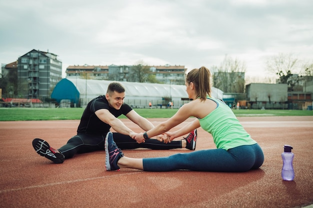 Photo friends exercising together on sports track