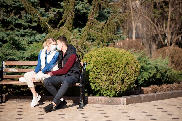 Friends in face masks walk in the park for fear of becoming infected with coronavirus.