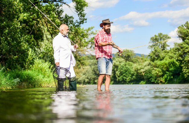 Friends fishing Perfect weekend Successful catch Elegant bearded man and brutal hipster fishing Hobby and recreation Family day Fishing team Relax in natural environment Summer vacation