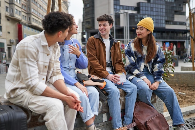 Friends from different cultures laughing and resting on a bench after arriving for vacation