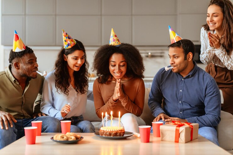Photo friends gathered around birthday cake have home party