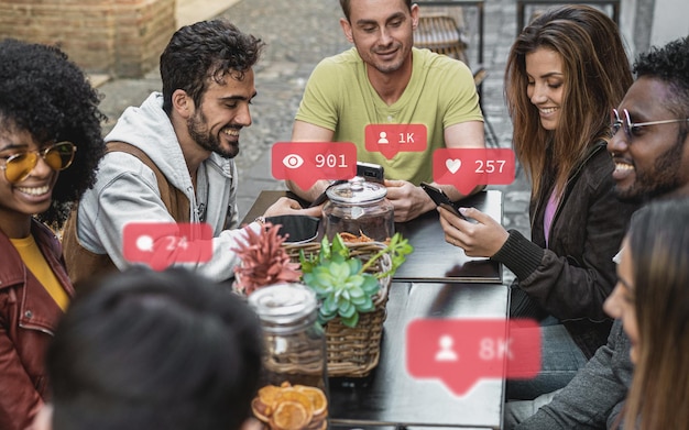friends gathering and cheering together. group of young people using smartphone, the internet and social media up. graphic overlays with like, views and message numbers.