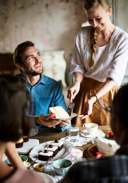 Amici che si riuniscono insieme su tea party eating cakes enjoyment happiness