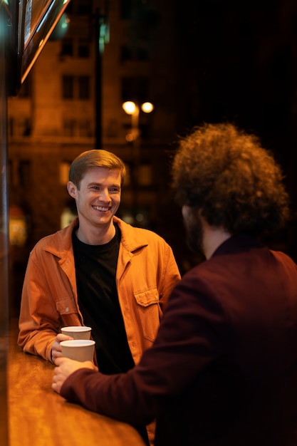 Foto amici che prendono il tè durante una serata fuori