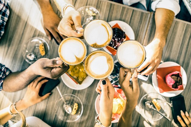 Foto gruppo di amici che beve cappuccino al ristorante bar caffetteria