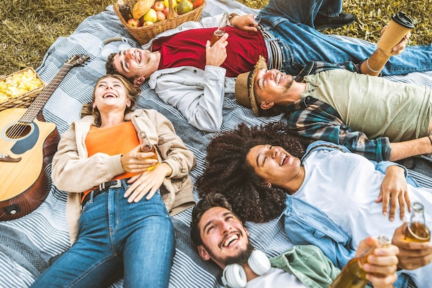 Friends group having fun together lying on the grass