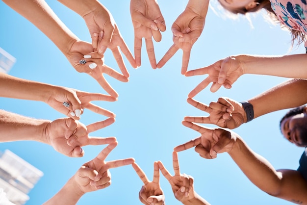 Friends hands and star sign by volunteer group in support of environment cleaning project in summer blue sky from below Peace collaboration and teamwork by happy people gathering to help community