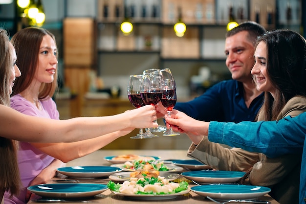 Gli amici si divertono in un ristorante e bevono vino