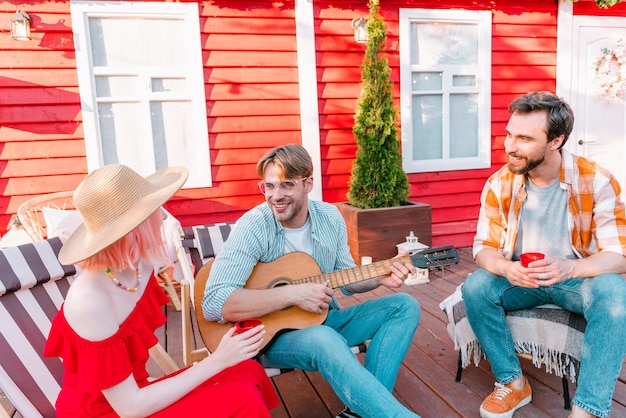 Friends have a picnic and play with guitar