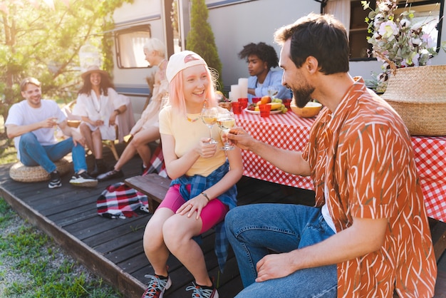 Friends have a picnic with a camper in a sunny day