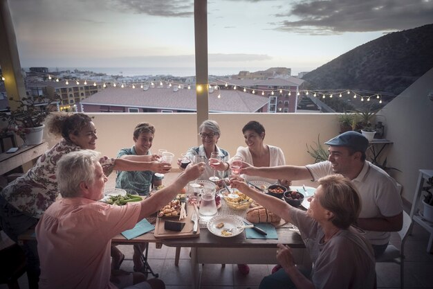 Amici che fanno una festa barbecue al tramonto nel patio dell'attico