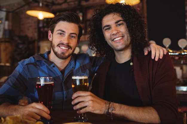 Amici che bevono birra al bancone del bar