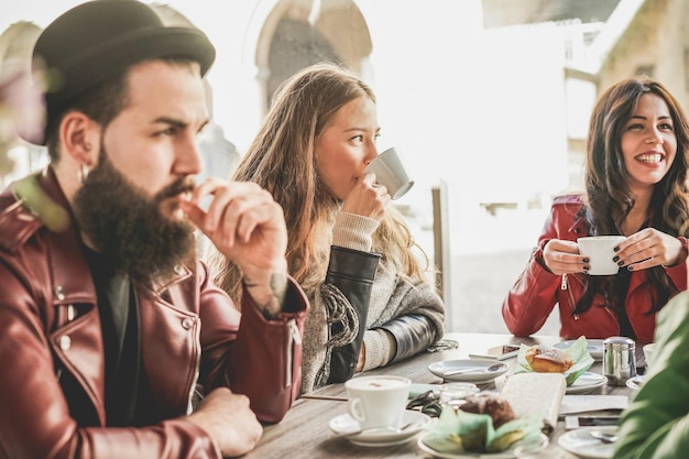 写真 カフェのテーブルでコーヒーを飲む友達