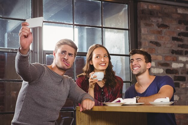 Friends having coffee and taking funny selfies