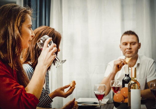 Foto amici che mangiano cibo e vino rosso sul tavolo da pranzo al ristorante